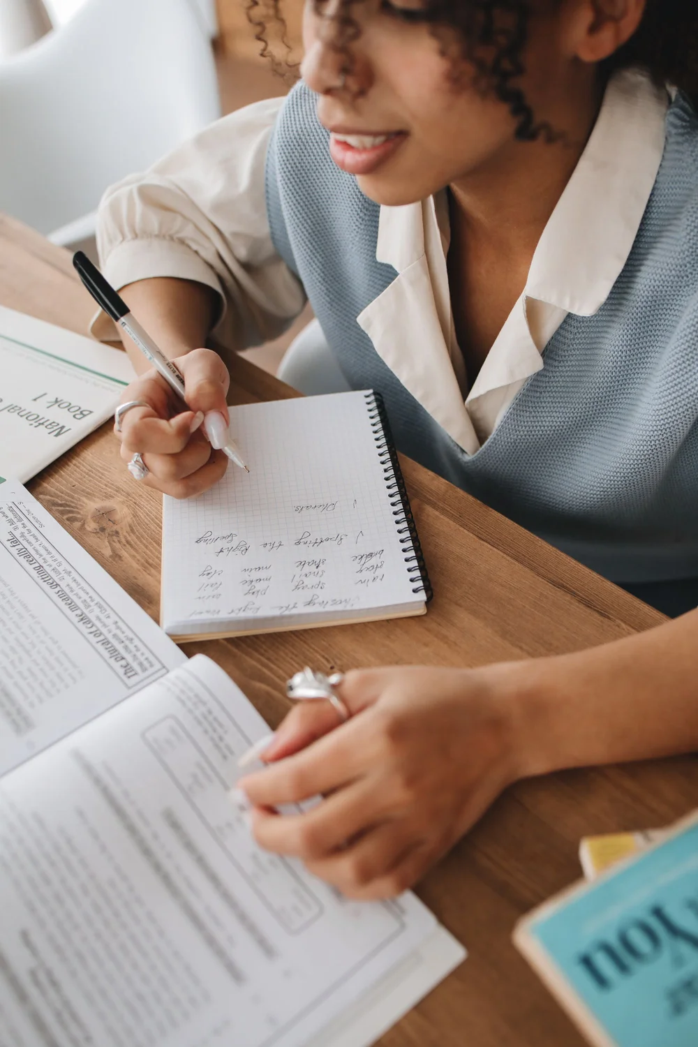 A learner taking notes while reading a textbook. · Illustrative stock photo